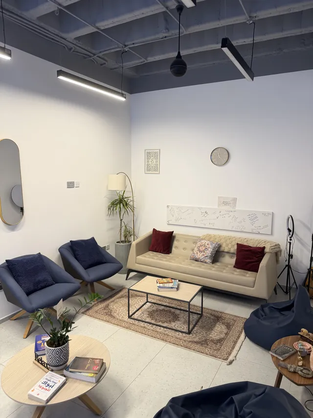 A relaxed room with a sofa, armchairs, a rug and a floor lamp