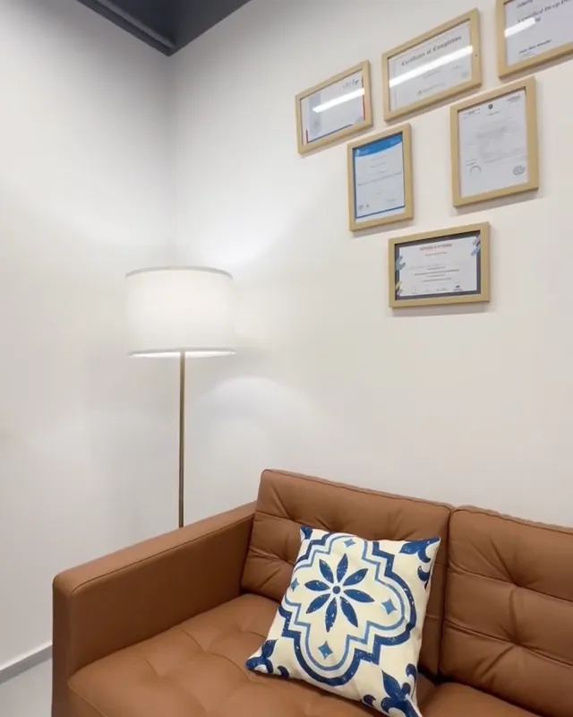 A therapy room with a leather sofa and floor lamp