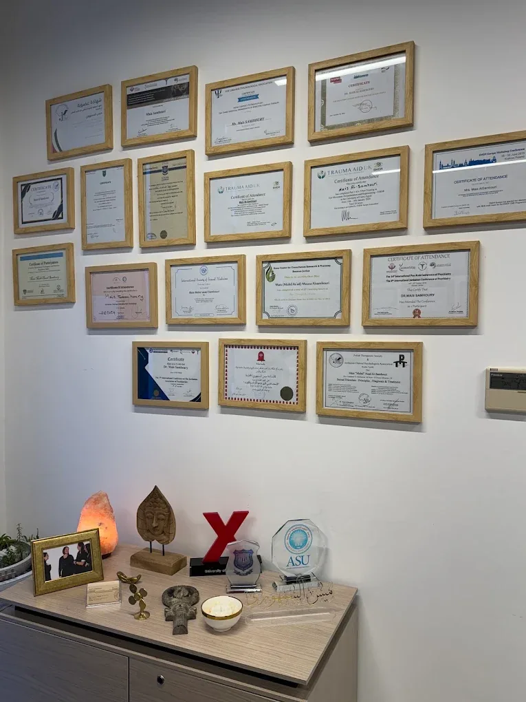 A wall of framed certificates and licenses at Mais Samhoury Center