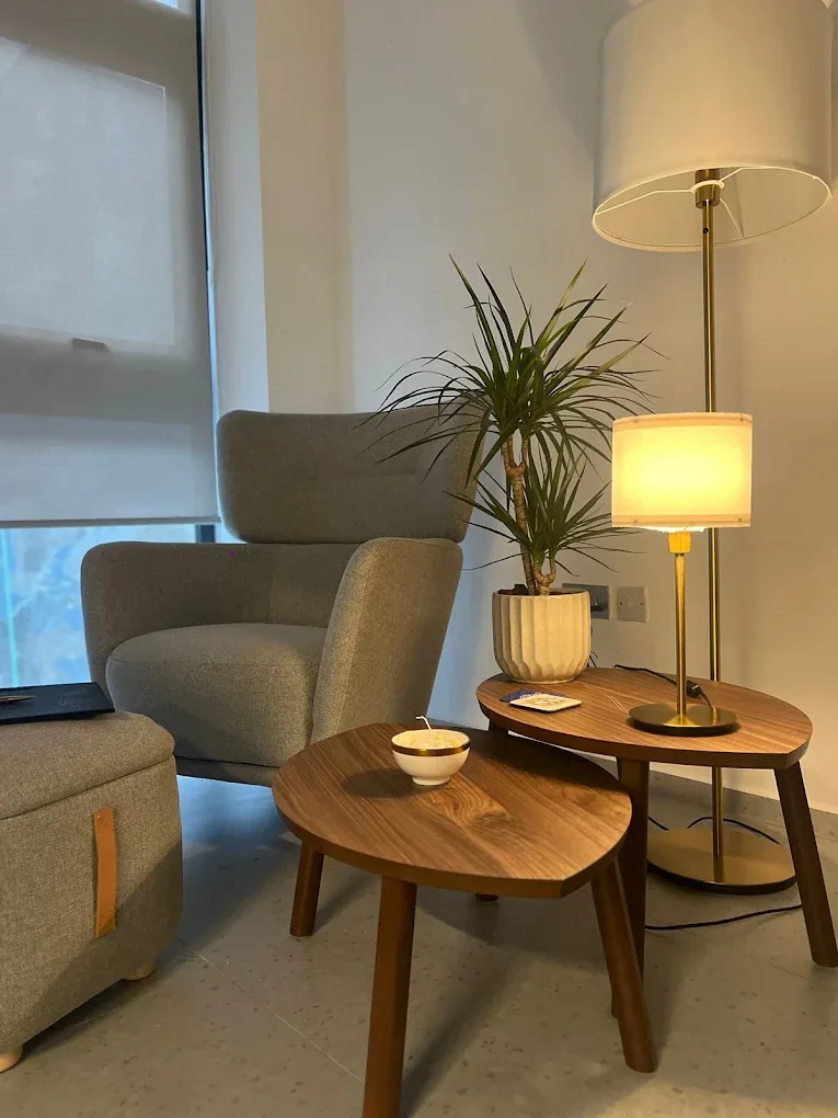 A calm therapy room at Mais Samhoury Center, with an armchair, side tables and warm lamps